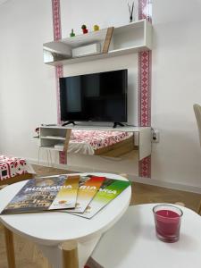 a living room with a white table and a tv at Studio Shevitsa & free Garage in Veliko Tŭrnovo