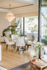 a dining room with white chairs and a table at Boutique Hotel Vissi d'Arte in Budva