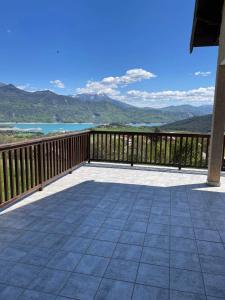 a large deck with a view of the mountains at Appartement T3 avec vue sur le lac in Chorges