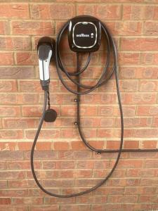 a black corded telephone hanging on a brick wall at Robins Nest Luxury Bungalow in Northampton