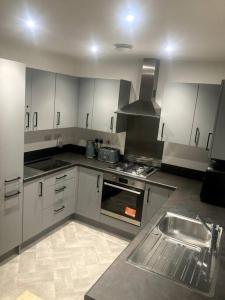 a kitchen with a stove and a sink in it at Robins Nest Luxury Bungalow in Northampton