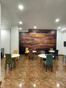 um quarto com mesas e cadeiras e uma parede de madeira em New House Kobuleti 2 em Kobuleti