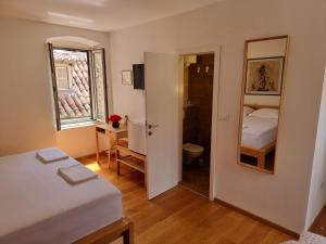 um pequeno quarto com uma cama e um espelho em Malena Palace Experience em Split