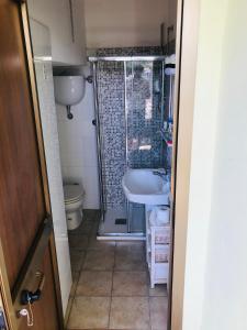een badkamer met een douche, een wastafel en een toilet bij Casa Belvedere in Mazzano Romano