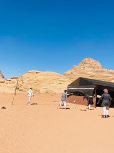 een groep mensen die een spel spelen in de woestijn bij Enjoy Wadi Rum stars in Disah