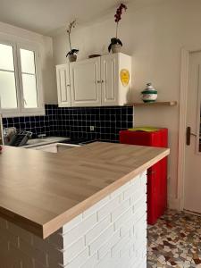 eine Küche mit weißen Schränken und einem roten Kühlschrank in der Unterkunft Havre de Paix 10 mn Centre Paris in Clichy