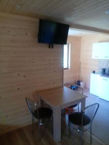 a dining room with a table and chairs and a television at Domki Bieszczady Całoroczne in Olszanica