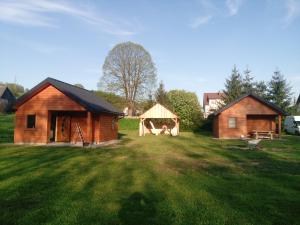 a couple of huts in a field with a yard at Domki Bieszczady Całoroczne in Olszanica