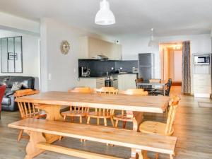 ein Esszimmer und eine Küche mit einem Holztisch und Stühlen in der Unterkunft Superbe appartement 6 pièces, 12 pers - Terrasse, garage, WIFI - FR-1-404-109 in La Mongie