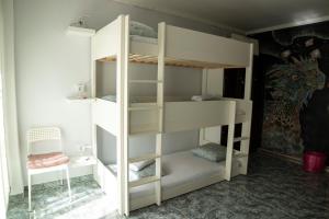 białe łóżko piętrowe z krzesłem w pokoju w obiekcie Habitación Familiar w Madrycie