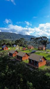 a group of houses in a field with trees at Infinity Valley Cabanas in Urubici