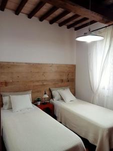 a bedroom with two beds and a table with a lamp at Appartamento - La Vinaccia in Montepulciano +10 photos