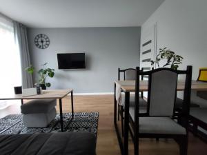 een woonkamer met een tafel en stoelen en een eetkamer bij Apartament Mineralny in Krynica Zdrój