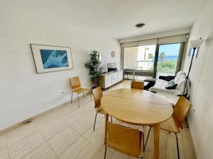 een woonkamer met een houten tafel en stoelen bij Tierra de Mar 77 in Denia