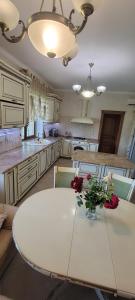 a kitchen with a white table with flowers on it at Трушки34/1 in Trushki