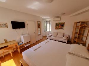 Cette chambre comprend un lit, un canapé et une télévision. dans l'établissement Malena Palace Experience, à Split
