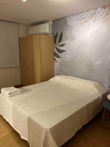 een slaapkamer met een wit bed en een houten kast bij Terrazas RV Adults Only No se cobran los impuestos in Posadas