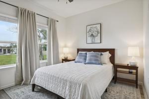 Dormitorio blanco con cama con almohadas azules en Vacation Rental in Old Town Bay St Louis plus parking for RV en Bay Saint Louis
