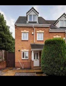 a large brick house with a white door at Hills Close in Mexborough