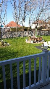 a white fence next to a yard with benches at 2 bed lodge sleeps 6 in Rhyl