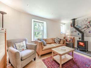 ein Wohnzimmer mit einem Sofa und einem Stuhl in der Unterkunft Tan Y Castell Cottage in Lampeter-Velfrey