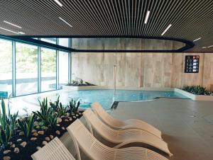 een zwembad met een bank in een gebouw bij Wave SPA Gold Apartment in Międzyzdroje