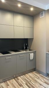 a kitchen with white cabinets and a sink at Apartament Paula in Władysławowo