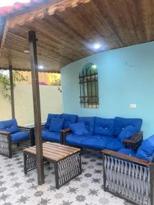 uma sala de estar com um sofá azul e mesas em villa Rima em Shūnat Nimrīn