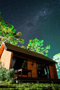 a cabin under a starry night sky with trees at Infinity Valley Cabanas in Urubici