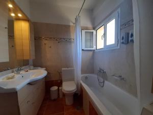 uma casa de banho com um lavatório, uma banheira e um WC. em Arbutus house em Preveza