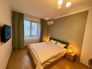 Un dormitorio con una cama grande y una ventana en Solid Residence Apartamente, en Mamaia