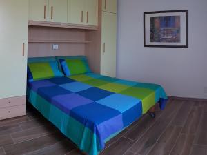 La Maison de André في Scaltenigo: سرير في غرفة باللون الأزرق والأخضر