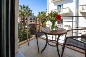 a vase of flowers sitting on a table on a balcony at Sophia Central Loft & Apartments in Argostoli