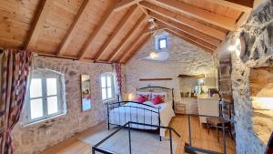 a bedroom with a bed and a stone wall at House Agava in Veliko Grablje