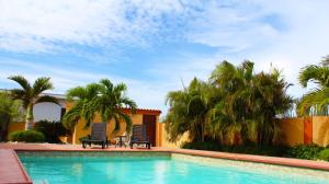 諾德的住宿－日出別墅，一个带两把椅子的游泳池,棕榈树