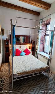a bedroom with a canopy bed with red and blue pillows at Charm Old Town Studio in Braşov