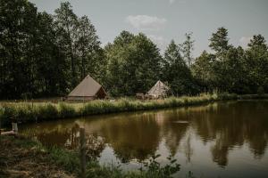 a couple of tents next to a river at Szykidym in Hartowiec