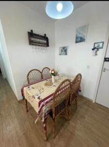 une salle à manger avec une table et quatre chaises dans l'établissement Martinica24D - Lindo apartamento a 800m PRAIA da MARTIM DE SÁ e PRAINHA - Wi-fi e Petfriendly, à Caraguatatuba