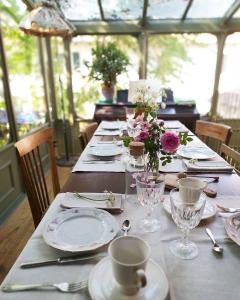 a long table with plates and glasses and flowers on it at La Vispa Ceresa in Castellinaldo