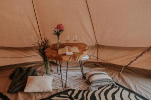 a table in a tent with a flower and a book at Szykidym in Hartowiec