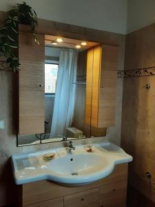 uma casa de banho com um lavatório e um espelho grande em Arbutus house em Preveza