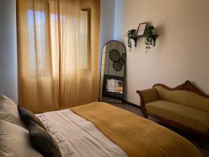 1 dormitorio con cama, silla y espejo en Casa Riva, en Crema