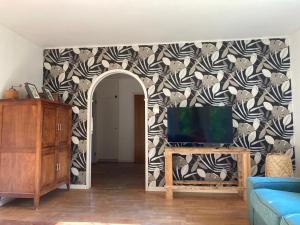 a living room with a tv and a patterned wall at Ta det lugnt in Råda