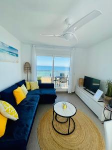 a living room with a blue couch and a table at Seafront La Manga Apartment in La Manga del Mar Menor