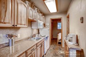 a kitchen with a sink and a white refrigerator at Outstanding Top Floor Condo, Stunning Updates with Meticulous Touches Throughout PM7C in Breckenridge