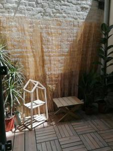 einem Holzstuhl auf einer Terrasse mit Pflanzen in der Unterkunft Chez mamie framboise centre ville avec courette in Dieppe