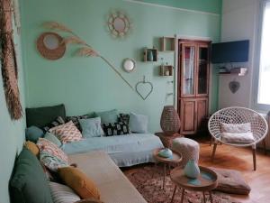 ein Wohnzimmer mit einem Sofa und 2 Tischen in der Unterkunft Chez mamie framboise centre ville avec courette in Dieppe