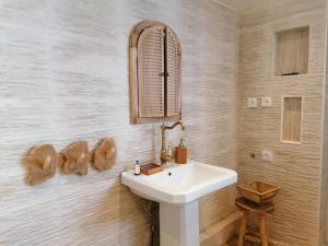 ein Badezimmer mit einem weißen Waschbecken und einem Spiegel in der Unterkunft Chez mamie framboise centre ville avec courette in Dieppe