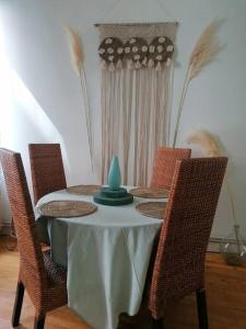 einen Tisch mit Stühlen und eine blaue Vase darauf in der Unterkunft Chez mamie framboise centre ville avec courette in Dieppe
