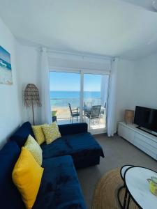 a living room with a blue couch and a view of the ocean at Seafront La Manga Apartment in La Manga del Mar Menor